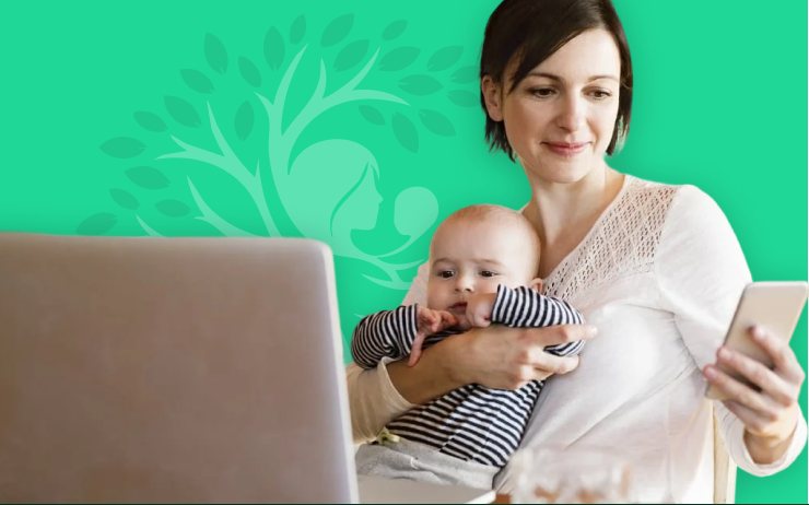 A mother holding her baby while using her phone.