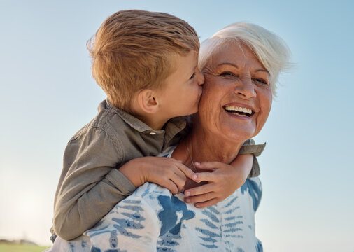 A grandmother laughing as her grandson hugs her.